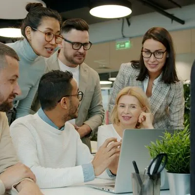 Team collaborating around a laptop