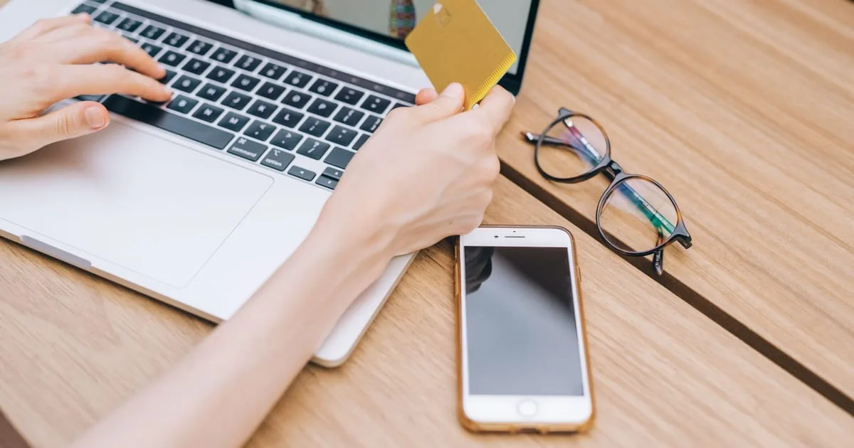 Shopper paying with a credit card at a laptop checkout, for a guide to ecommerce conversion rates