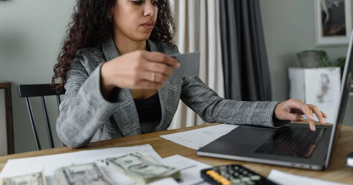 Small business owner reviewing a website budget on a laptop at a shop counter