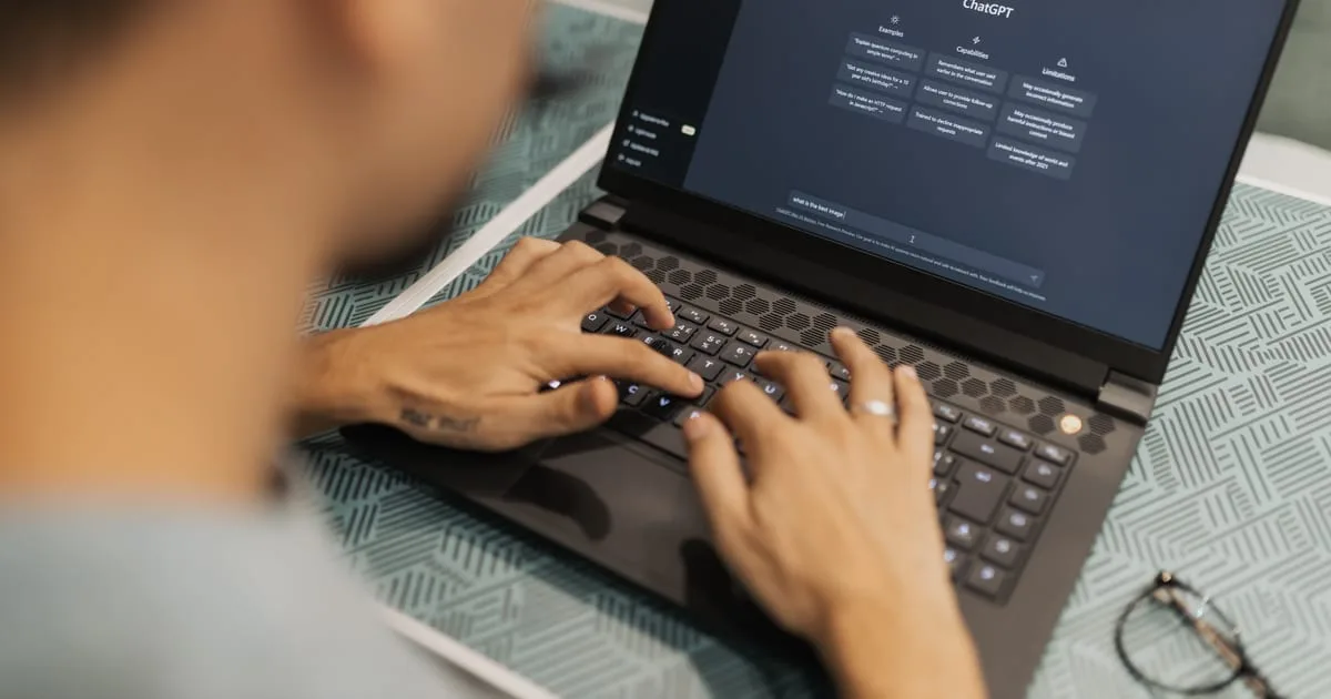 Marketing manager at a desk reading an AI chatbot answer with numbered source citations on a laptop