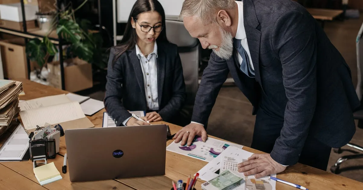 Small business team reviewing an automated workflow plan on a laptop in an office